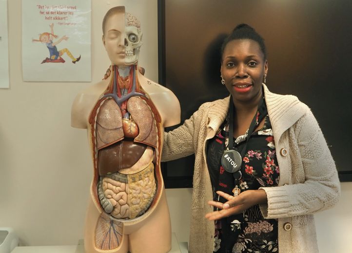 Foto: Katarina Hundal Fatou Ceesay i klasserommet med kjent følgesvenn i helsearbeiderfaget